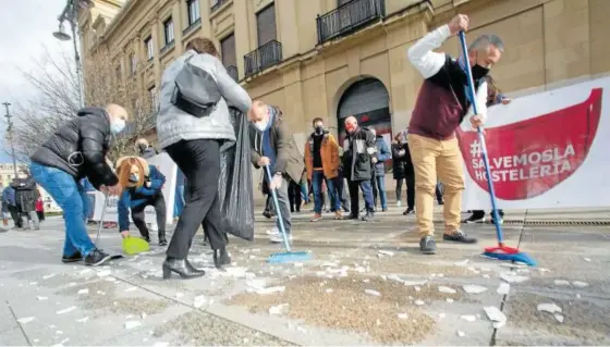  ??  ?? Hosteleros recogen unos platos utilizados en una protesta anterior contra la situación del sector.