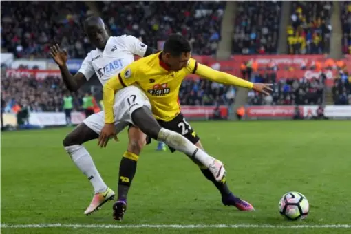  ?? (Getty) ?? Jose Holebas and Modou Barrow go shoulder-to-shoulder for the ball