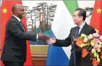  ?? WANG JING / CHINA DAILY ?? State Councilor and Foreign Minister Wang Yi greets Sierra Leone’s Foreign Minister Alie Kabba in Beijing on Friday.