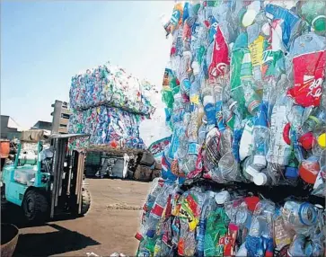  ?? Luis Sinco Los Angeles Times ?? BALES OF plastic beverage bottles are stacked high at a recycling center in Boyle Heights. The values of plastic, glass and aluminum have decreased, prompting many recycling centers to close in the last two years.