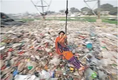  ??  ?? A Bangladesh­i girl plays on a swing, in Dhaka, Bangladesh. Bangladesh garment manufactur­ers have sacked at least 1,500 workers, police said, after protests over pay led to a weeklong shutdown at dozens of factories supplying top Western brands. —...
