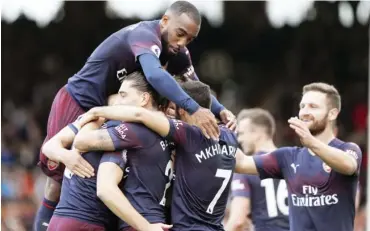  ?? Photo: AFP ?? Arsenal's Welsh midfielder Aaron Ramsey celebrates with teammtes after scoring the team's third goal during the English Premier League match against Fulham at Craven Cottage in London, yesterday