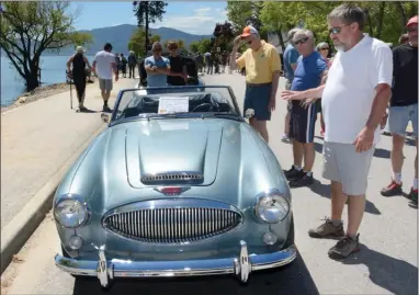  ?? GARY NYLANDER/The Daily Courier ?? Visitors to the 20th annual Peachland World of Wheels Show and Shine admire a 1965 Austin Healey owned by Randy Brophy of Peachland. Sunday’s car show along Beach Avenue and in Heritage and Cousins parks featured about 500 vehicles and attracted an...