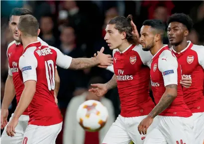  ?? — AP ?? Arsenal’s Hector Bellerin (centre) celebrates with teammates after scoring during the Europa League Group H match against FC Cologne in London Thursday.