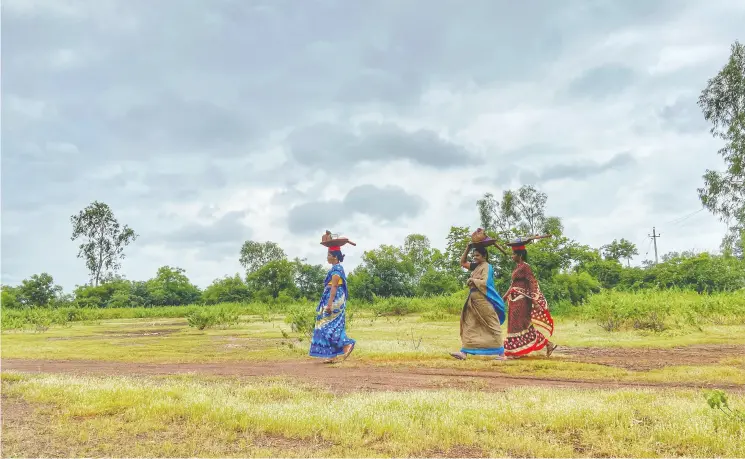  ?? PHOTOS: NIHA MASIH / THE WASHINGTON POST ?? Women employed in a rural public works program walk to the work site in Kamthana, in the southern Indian state of Karnataka, last month.