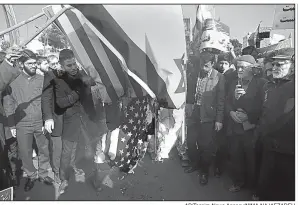  ?? AP/Tasnim News Agency/NIMA NAJAFZADEH ?? Iranians burn U.S. and Israeli flags at a pro-government demonstrat­ion Thursday in the city of Mashad.