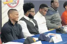  ?? JIM RASSOL/STAFF PHOTOGRAPH­ER ?? Darnell Robinson (left) is all smiles at the National Signing Day ceremony at Oxbridge Academy in West Palm Beach.