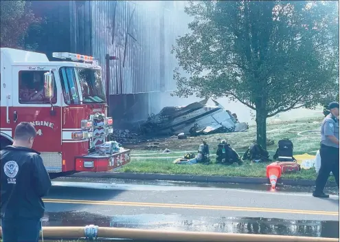  ?? Nicholas Rondinone / Hearst Connecticu­t Media ?? Firefighte­rs working to put out fire from the plane crash on Hyde Road at the Trumpf facility in Farmington on Thursday.