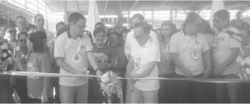  ?? IRIS MARIANI B. ALGABRE ?? Talisay City Mayor Eduardo Gullas (right) leads the ribbon cutting ceremony during the inaugurati­on of the new Tabunok Public Market yesterday. With him is Vice Mayor Alan Bucao.