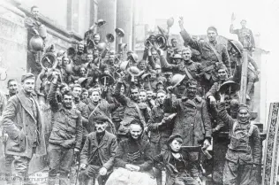  ?? National World War I Museum and Memorial / Associated Press ?? Celebratio­ns on Nov. 11, 1918, mark Company A, 353rd Regiment Infantry, 89th Division, at the church steps in Stenay in eastern France at 11 a.m., the moment of the start of the armistice.