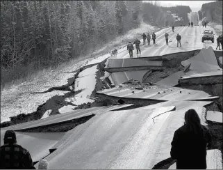  ?? JONATHAN M. LETTOW VIA AP ?? IN THIS PHOTO PROVIDED BY JONATHAN M. LETTOW, people walk along Vine Road after an earthquake Friday in Wasilla, Alaska.