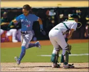  ?? TONY AVELAR — THE ASSOCIATED PRESS ?? Toronto Blue Jays’ Bo Bichette, left, scores a run past A’s catcher Sean Murphy on a single by Teoscar Hernandez during the sixth inning in Oakland on Thursday.