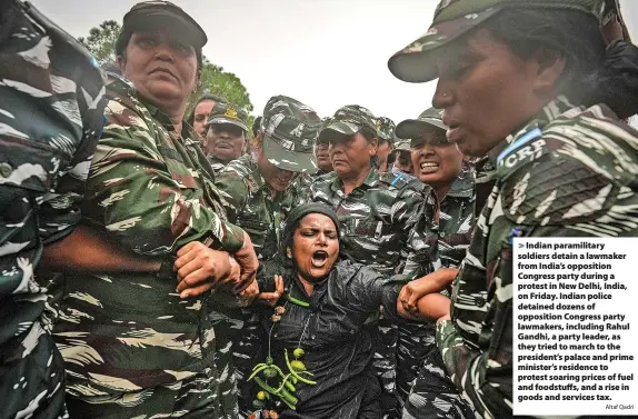  ?? Altaf Qadri ?? Indian paramilita­ry soldiers detain a lawmaker from India’s opposition Congress party during a protest in New Delhi, India, on Friday. Indian police detained dozens of opposition Congress party lawmakers, including Rahul Gandhi, a party leader, as they tried to march to the president’s palace and prime minister’s residence to protest soaring prices of fuel and foodstuffs, and a rise in goods and services tax.