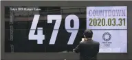  ?? Jae C. Hong / Associated Press ?? A man takes pictures of a countdown display for the Tokyo 2020 Olympics.