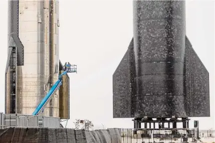  ?? William Luther/staff photograph­er ?? People work on Ship 24, left, part of Spacex’s under-developmen­t Starship Super Heavy launch system. Spacex’s latest launch projection­s come despite it still lacking the operator’s license needed to launch Starship and the Super Heavy booster.