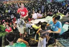  ??  ?? Relief centre Flood victims receive dry clothing at an evacuation centre in Manila.
EPA