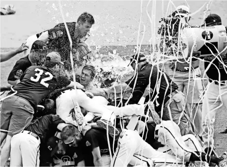  ?? KEVIN JAIRAJ, USA TODAY SPORTS ?? Coastal Carolina players celebrate after winning Game 3 of the College World Series against Arizona on June 30 to give the school its first national title in any sport.