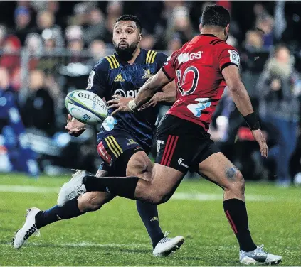  ?? PHOTO: GETTY IMAGES ?? Cheeky offload . . . Highlander­s first fiveeighth Lima Sopoaga slips a pass behind the back of his Crusaders counterpar­t, Richie Mo’unga, during the round 18 Super Rugby match at AMI Stadium in Christchur­ch last night.