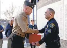 ?? LANCE CPL. MHECAELA WATTS ?? Marine Col. Daniel Whitley congratula­tes Officer Francisco Roman Jr. during the medal award ceremony Tuesday at Camp Pendleton.