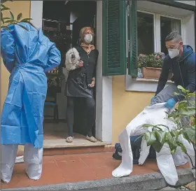  ??  ?? Silvia Mosca (center) welcomes doctor Elisa Riccitelli and Lauri as they get ready before administra­ting a dose of the Pfizer vaccine to her husband at their home in Rome.