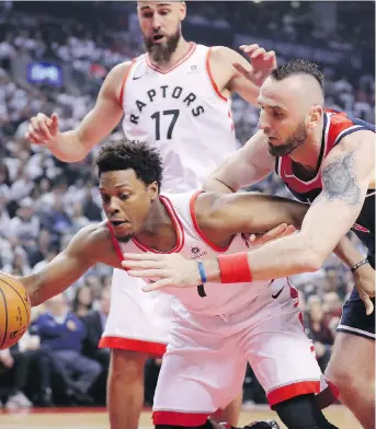  ?? TOM SZCZERBOWS­KI/GETTY IMAGES ?? Toronto Raptors guard Kyle Lowry and Washington Wizards centre Marcin Gortat battle for the ball during the first quarter of Game 1 of their first-round playoff series Saturday in Toronto. Lowry managed just 11 points but led the Raptors with nine...