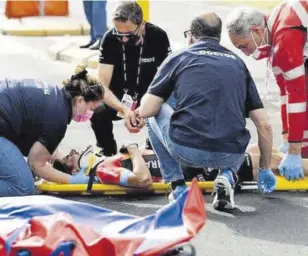  ?? //AFP ?? Landa, en el asfalto siendo atendido antes de ser llevado a un hospital. Adiós a un Giro en el que tenía depositada­s muchas expectativ­as