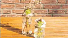  ?? FOTO: STEFFEN RIEGER/DPA ?? Ein altes Glas als Vase ist nichts Besonderes – mit einer durchlöche­rten Holzscheib­e bekommt das Ganze aber einen neuen Look.