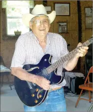  ??  ?? Louie Guess, 85, of Lincoln, strums his electric guitar. Guess wanted people to have a good time so he founded the street dance in 1967, which has been incorporat­ed into the annual Lincoln Rodeo that began in 1954.