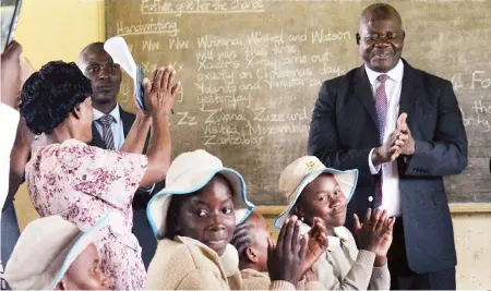  ?? — Picture: Charles Muchakagar­a. ?? Primary and Secondary Education Minister Torerayi Moyo and some delegates interact with pupils during an opening day assessment tour at Makomo Primary School in Epworth, Harare yesterday.