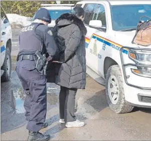  ?? CP PHOTO ?? An asylum claimant claiming to be from Turkey is handcuffed after crossing the border into Canada from the United States Thursday near Hemmingfor­d, Que. A growing number of people have been walking across the border into Canada to claim refugee status,...