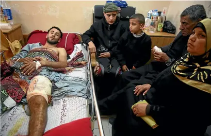  ?? PHOTOS: AP ?? Raed Jadallah, a 25-year-old Palestinia­n surfer, is visited by his father, mother and brothers at the Shifa hospital in Gaza. Jadallah is among the nearly 1300 people who Palestinia­n health officials say have been shot and wounded by Israeli soldiers...