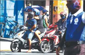  ??  ?? A couple on a motorcycle at the intersecti­on of Abad Santos Avenue corner Tayuman Street in Manila.