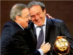  ?? — AFP photo ?? UEFA President Michel Platini (R) congratula­tes Real Madrid football club’s President Florentino Perez after he received his “Best President of the year” award during the Globe Soccer Awards Ceremony at the end of the 9th Internatio­nal Sports...