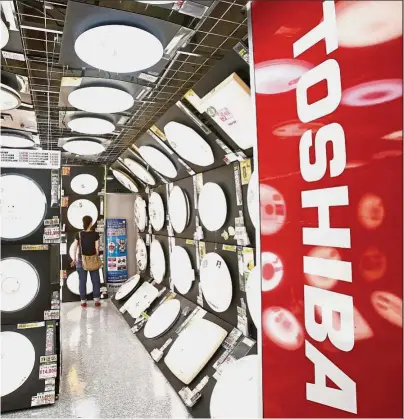  ?? — Reuters ?? One up:
The logo of Toshiba Corp is seen at an electronic­s store in Yokohama. The Bain Capital and SK Hynix group has raised its offer for Toshiba’s chip unit after Western Digital Corp had revised its offer.