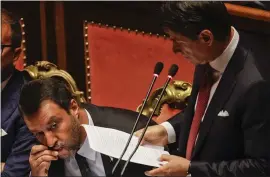  ?? GREGORIO BORGIA — THE ASSOCIATED PRESS ?? Italian Premier Giuseppe Conte addresses the Senate as Interior Minister Matteo Salvini kisses a rosary while sitting beside him, in Rome on Tuesday.