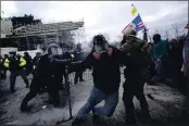  ?? JULIO CORTEZ — THE ASSOCIATED PRESS ?? Trump supporters try to break through a police barrier at the Capitol in Washington on Wednesday.