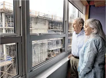  ?? ALIE SKOWRONSKI askowronsk­i@miamiheral­d.com ?? David Schaecter, an original Grove Isle resident, left, and his wife, Sydney, stare at the new condo building going up across from their unit in Building 3.