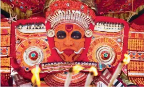  ??  ?? A Theyyam performer in his vibrant makeup and costume