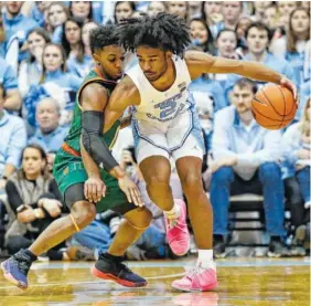  ?? AP PHOTO/GERRY BROOME ?? North Carolina’s Coby White dribbles against Miami’s Chris Lykes during overtime Saturday in Chapel Hill, N.C. North Carolina won 88-85.