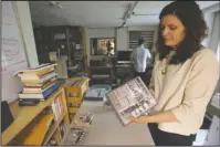  ?? The Associated Press ?? MUSIC MARKET NICHE: April Ledbetter holds a copy of "Voices of Mississipp­i," a box set of recordings released by Dust-To-Digital, in Atlanta on May 29. Ledbetter and her husband Lance Ledbetter operate Dust-to-Digital, a record label that digitizes and...