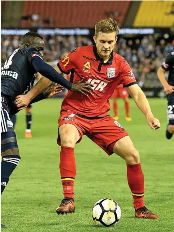  ?? PHOTO: JOE CASTRO ?? ON THE BALL: Ryan Kitto of Adelaide holds off a Melbourne Victory rival during last week’s A-League clash.