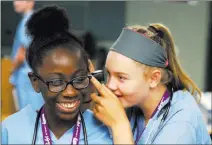  ?? Erik Verduzco ?? Las Vegas Review-journal @Erik_verduzco Halsey Hughes peers into the ear of fellow camper Damera Spann during a Campmed lab rotation.