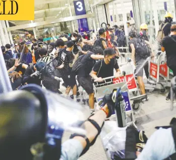  ?? TYRONE SIU / REUTERS ?? Riot police use pepper spray to disperse protesters at Hong Kong’s internatio­nal airport Tuesday at a mass
demonstrat­ion after forces there shot a woman in the eye with a projectile, blinding her.