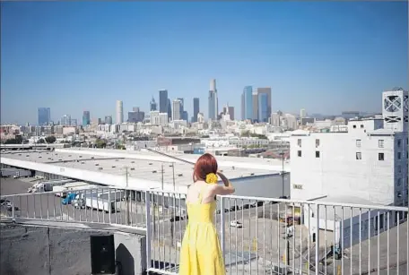  ?? Jenna Schoenefel­d For The Times ?? MELINDA RICE adds musical accompanim­ent to a rooftop scene in “Hopscotch” as the downtown Los Angeles skyline looms ahead.