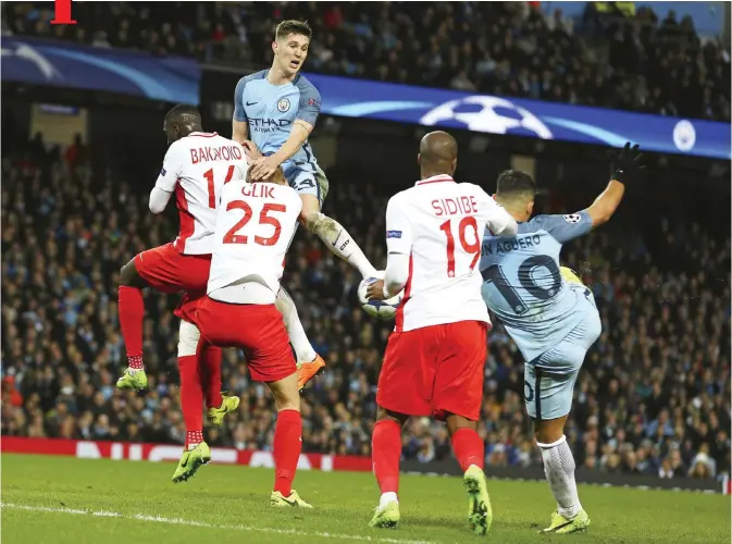  ?? — AP ?? MANCHESTER: Manchester City’s Sergio Aguero, right, scores his side’s third goal during the Champions League round of 16 first leg soccer match between Manchester City and Monaco at the Etihad Stadium in Manchester, England, yesterday.