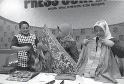  ?? DEBORA DANISA S./JAWA POS ?? PARTISIPAS­I: Ketua Dekranasda Surabaya Nanies Chairani (tengah) menunjukka­n batik canting yang menjadi salah satu item pameran yang dibuka hari ini.
