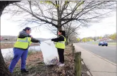  ??  ?? Volunteers Marisa Cos and her daughter Jaylisa, 10, clean up trash along North Division Street.