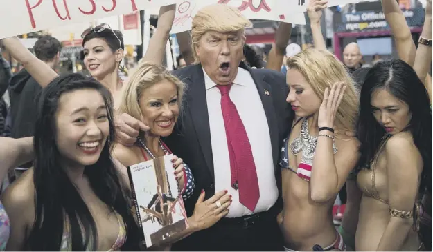  ?? PICTURE: GETTY IMAGES ?? 0 A Donald Trump lookalike with bikini-clad models, part of an artwork parodying the Republican candidate’s attitudes to women