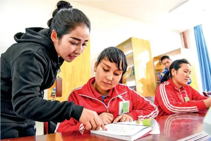  ??  ?? A teacher (1st L) instructs a trainee at a reading room of the vocational education and training center in Hotan county of Hotan Prefecture, northwest China’s Xinjiang Uygur Autonomous Region, Oct. 7, 2018. (Xinhua/hu Huhu)