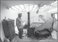  ?? AP/ The Topeka Capital- Journal/ THAD ALTON ?? Virgil Toombs of Abilene, Kan., stands Thursday in his bedroom that was wrecked when a tornado blew through Wednesday night, ripping the roof off the house.